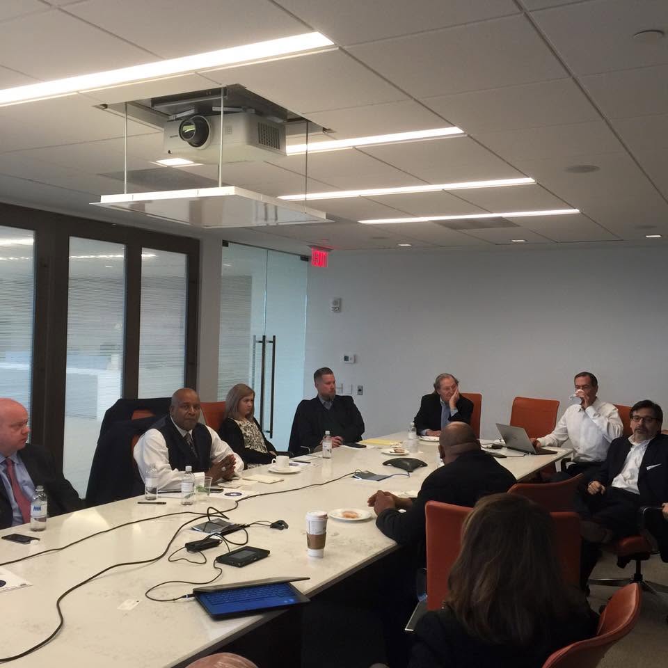 Participants seated around a conference table at an early Friday morning gathering.